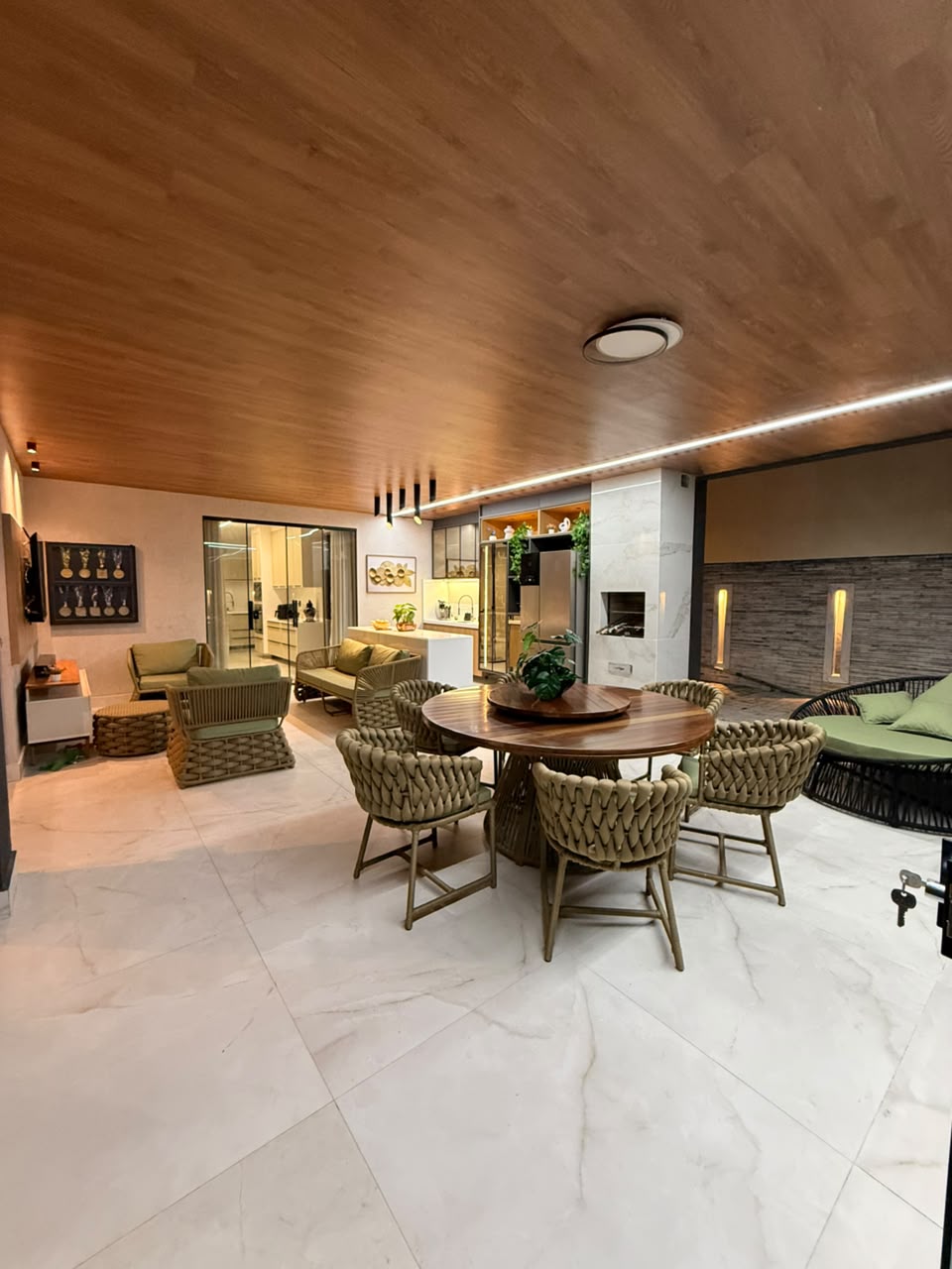 Área gourmet com mesa, churrasqueira e estar